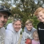 Family in park training for the Be Wise Walk, looking to camera