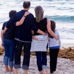 Family of four on the beach, looking out to sea
