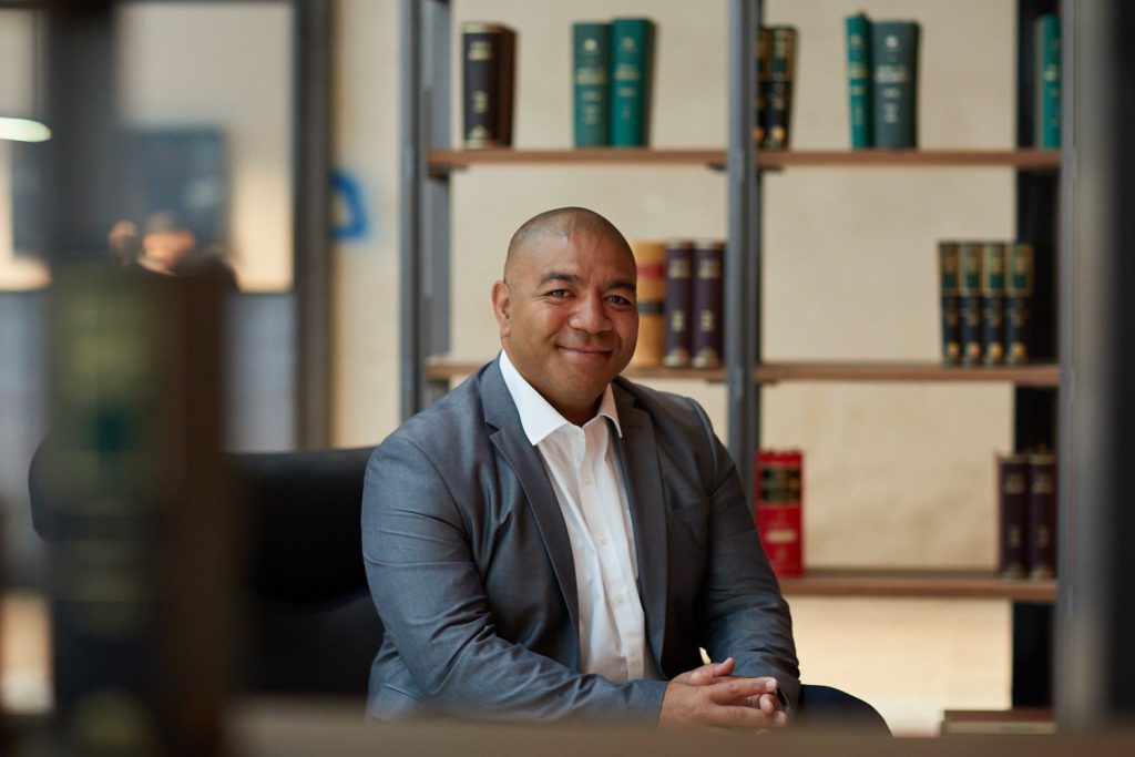 Man in a suit and sitting at a desk, profile shot