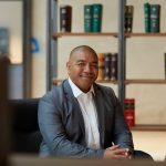 Man in a suit and sitting at a desk, profile shot